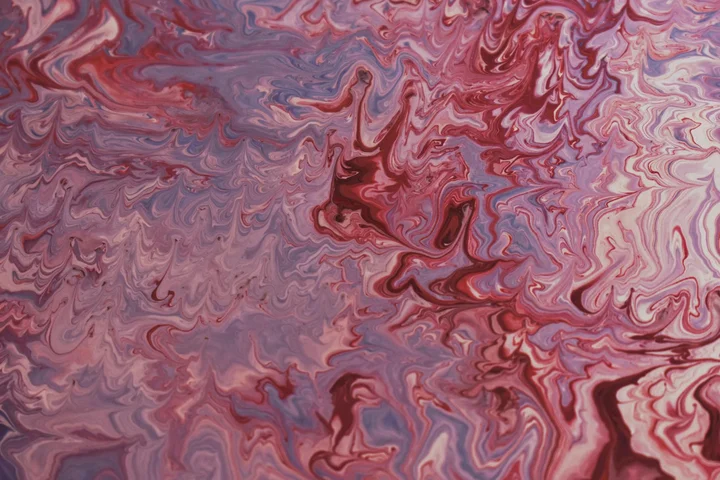 Abstract marbled painting with pink, red, and purple swirls.