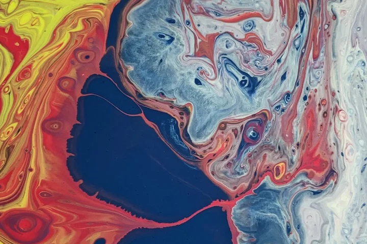 Abstract swirl of red, blue, yellow, and white paint