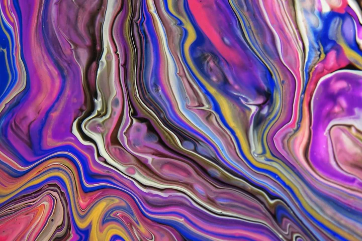 Abstract swirl of purple, pink, blue, and yellow marbling with no discernible objects.