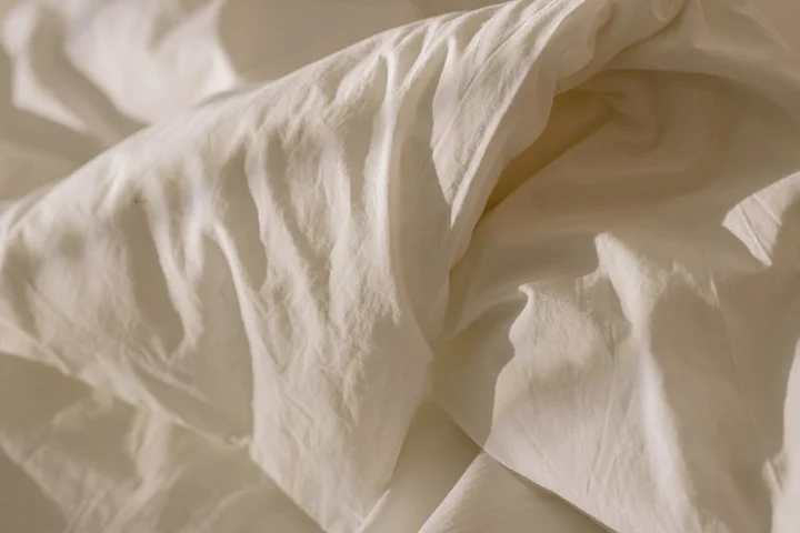 White fabric laid out to dry, showing wrinkles and folds