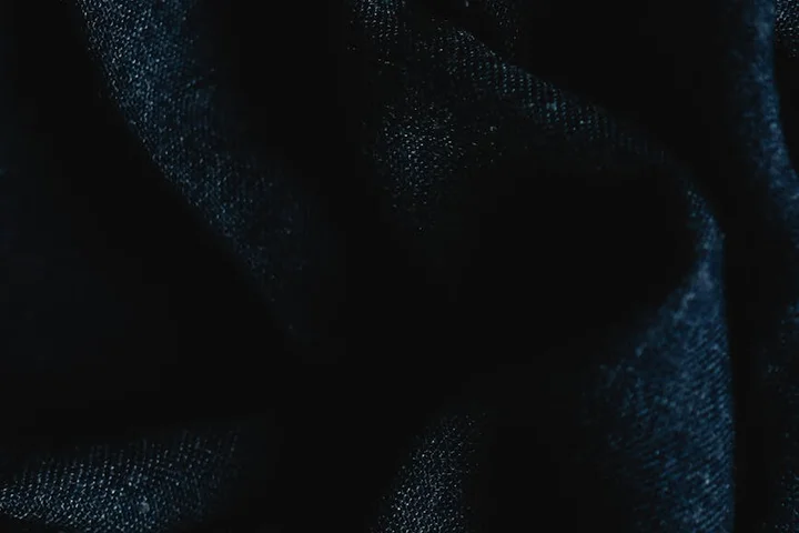 Close-up view of a dark blue rug fabric with subtle creases