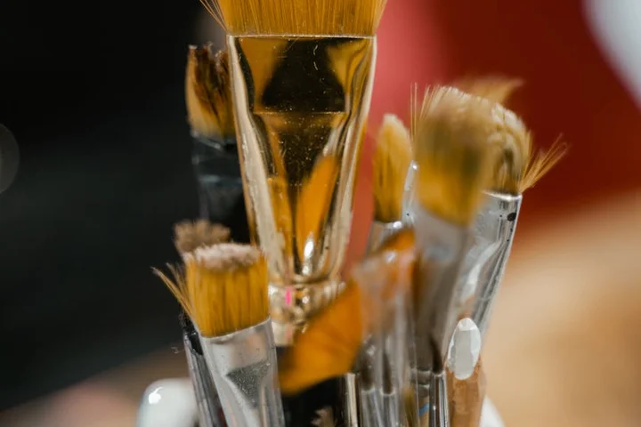 Close-up of several artist brushes with acrylic paint on the bristles