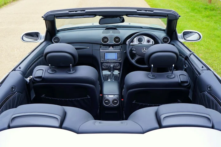 View of a black convertible car interior with front seats and dashboard, featuring leather upholstery.