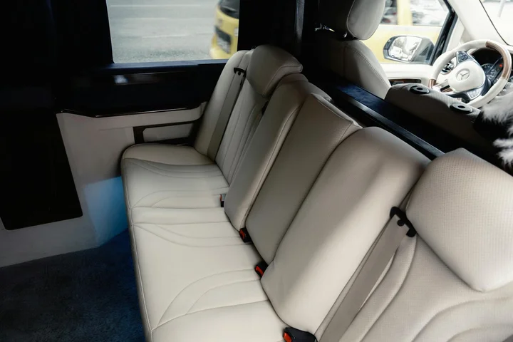 Cream-colored leather car seats with a visible dashboard and steering wheel inside a vehicle cabin, highlighting typical interior materials evaluated for stain resistance.