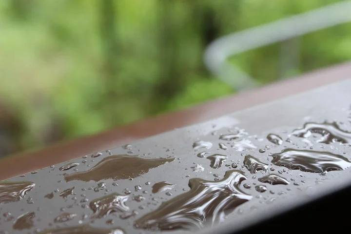Close-up of water droplets beading on a surface to illustrate stain resistance in carpets