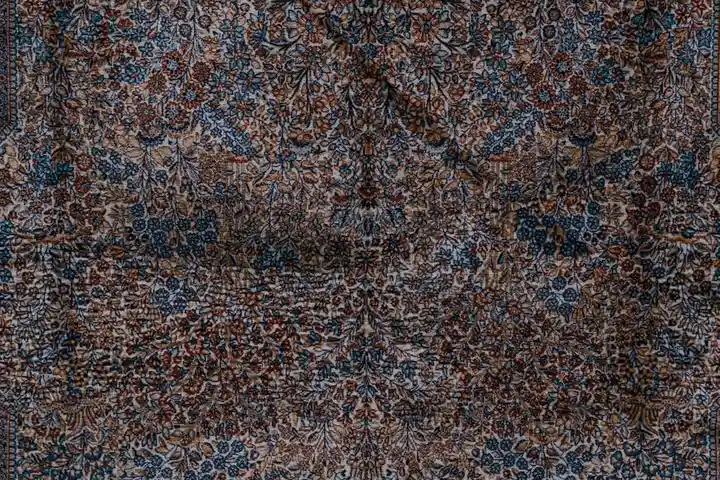 Close-up of a patterned carpet with visible staining and wear to illustrate carpet condition in rental properties.