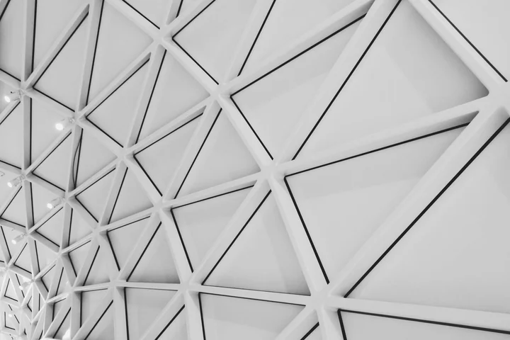 Monochrome ceiling with a repeating geometric triangular panel pattern