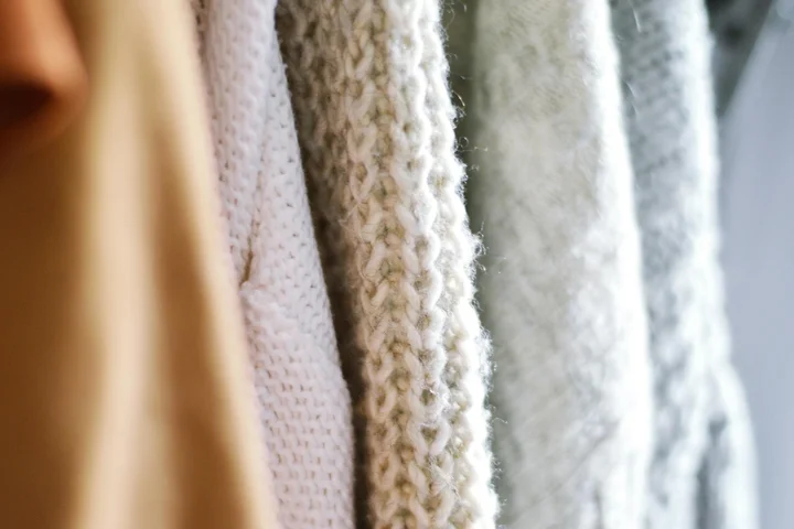 Close-up of knitted and textured fabrics in neutral tones hanging to dry, highlighting care for delicate textiles