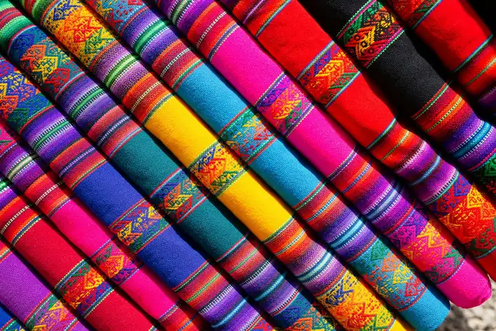 Colorful folded textiles with geometric patterns arranged in diagonal rows