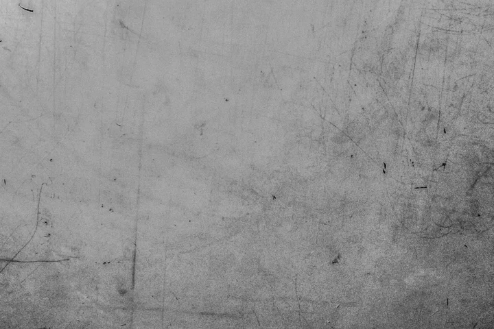 Gray concrete surface with scratches and faint stains.