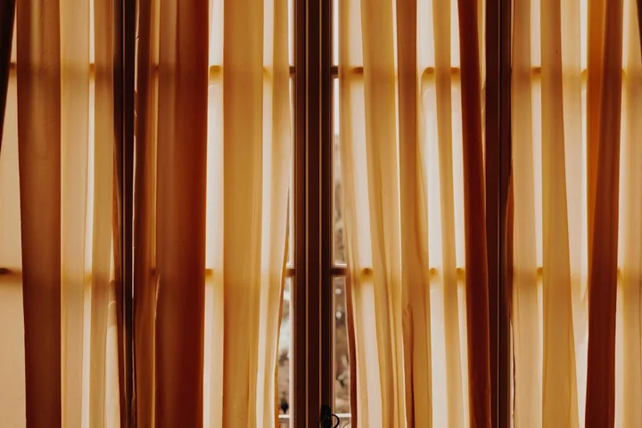 Brown sheer curtains with sunlight filtering through a window