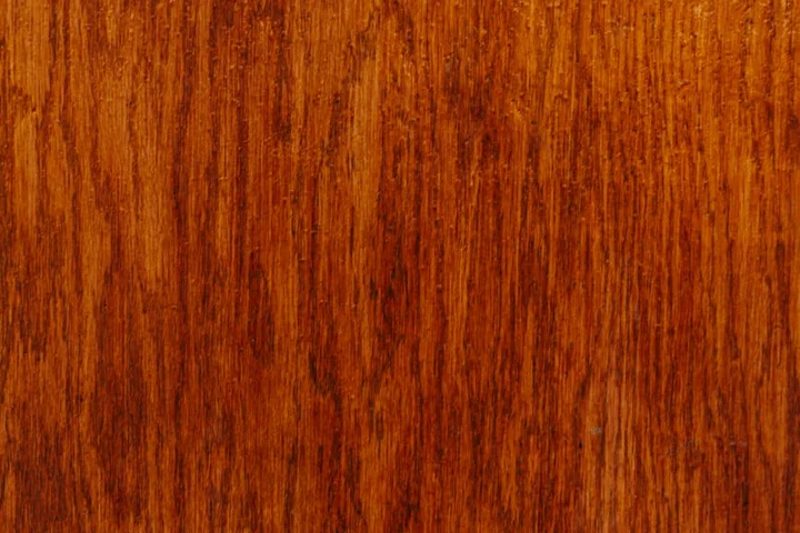 Close-up of a wood deck surface stained in warm brown color, showcasing prominent wood grain.