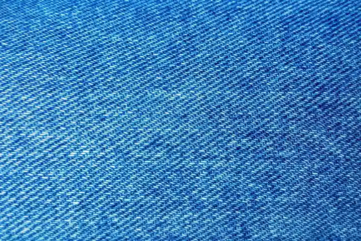 Close-up of blue denim fabric with visible diagonal weave.