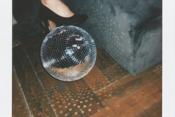 Disco ball resting on a hardwood floor next to a sofa