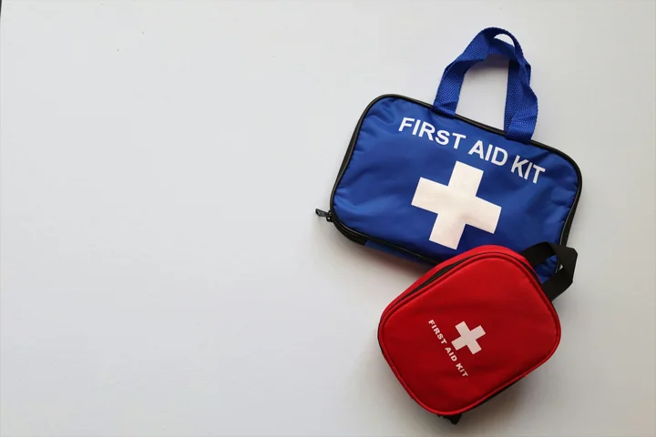Blue first aid kit and red pouch with white cross on a white background.