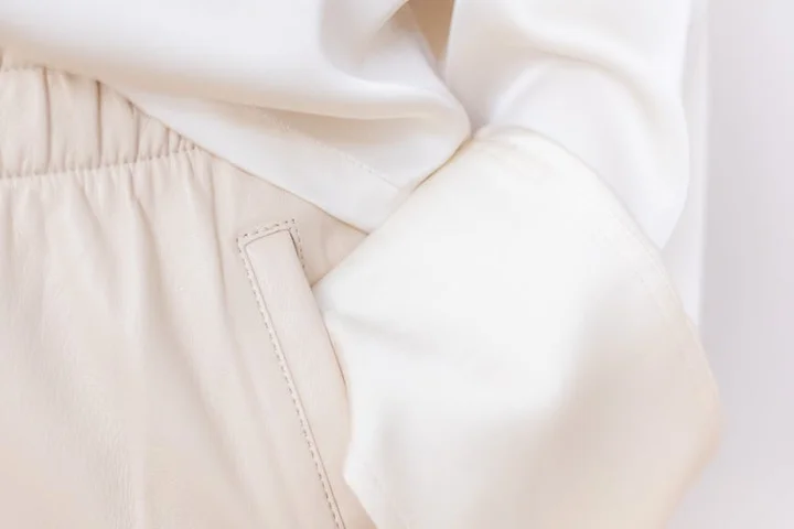 Close-up of light beige fabric with a pocket seam.