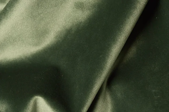 Close-up of olive-green satin fabric with a shiny surface and soft folds.