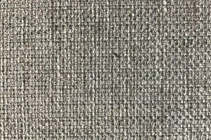 Close-up of woven upholstery fabric in neutral gray-beige tones.