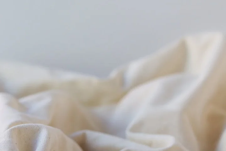 Close-up of light-colored fabric with soft folds, illustrating textiles beyond clothing