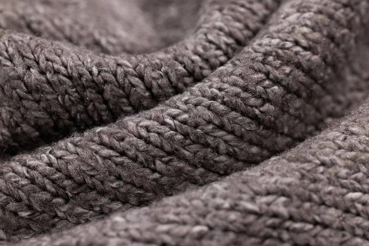 Close-up of soft gray-brown fabric with a chunky woven texture