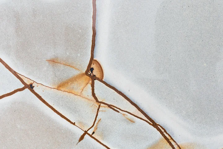Close-up of fabric with brown scorch/burn stains and irregular streaks.