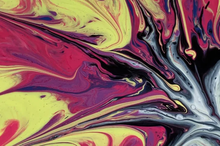 Abstract swirl of yellow, pink, purple, and blue paint resembling a hair dye spill on fabric, suggesting upholstery stains.