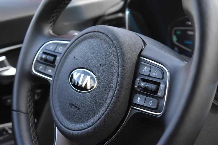 Close-up of a Kia steering wheel with control buttons on the right side.