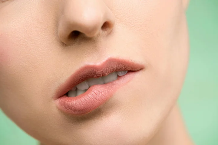 Close-up of a person's lips wearing pink lipstick