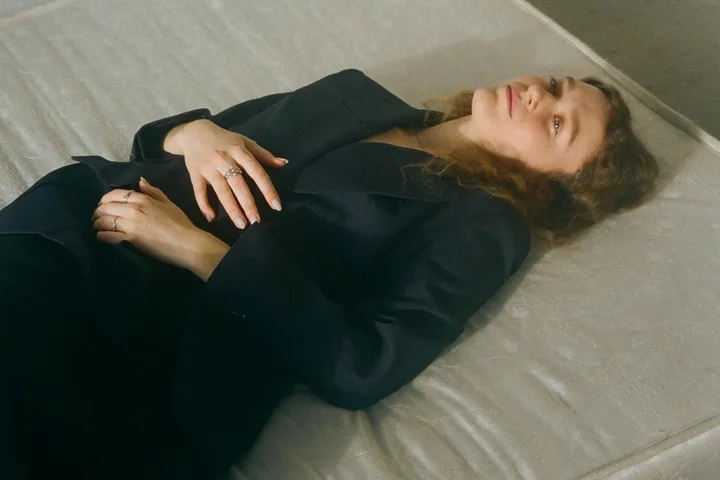 Person lying on a bare mattress, illustrating the final drying phase after cleaning.