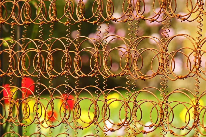 Close-up of metal mattress springs arranged in a repeating circular coil pattern