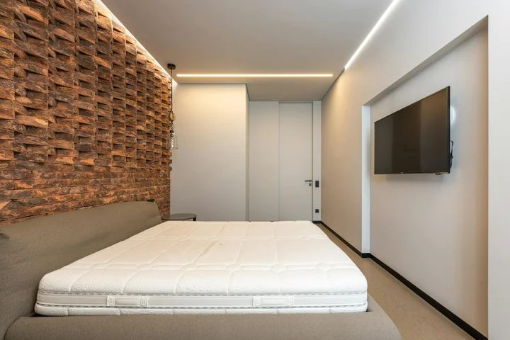 Modern bedroom with a memory foam mattress on a low-profile bed, showing space for air-drying after cleaning.