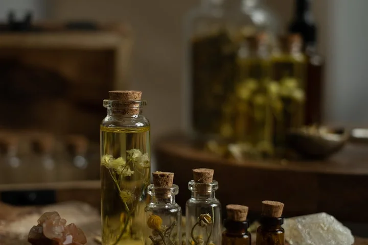 A vintage apothecary scene with glass bottles and cork stoppers containing herbs and oils, illustrating historical odor-control practices.