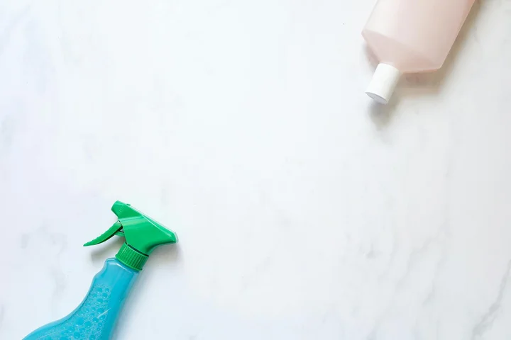 Two cleaning spray bottles on a light surface, representing household cleaners and the risk of hazardous chemicals.