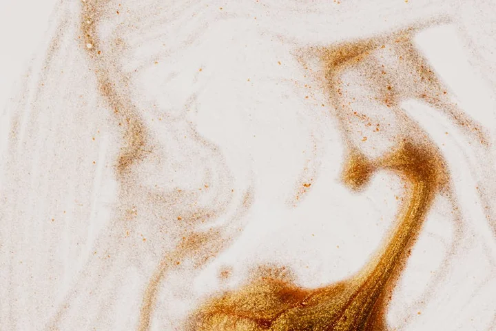 Close-up of a dried, set-in coffee stain on light-colored carpet fibers.