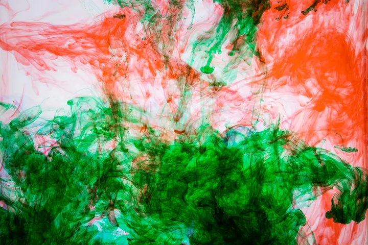 Abstract splash of red and green ink swirling in water