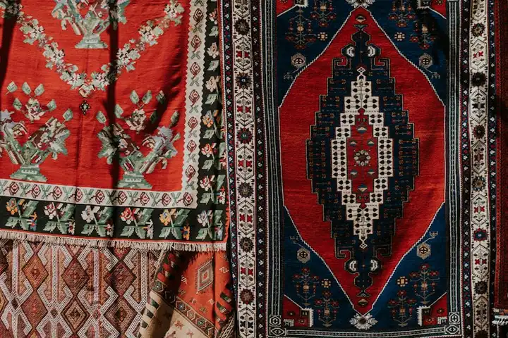 Colorful woven rugs with red, blue, and cream geometric patterns
