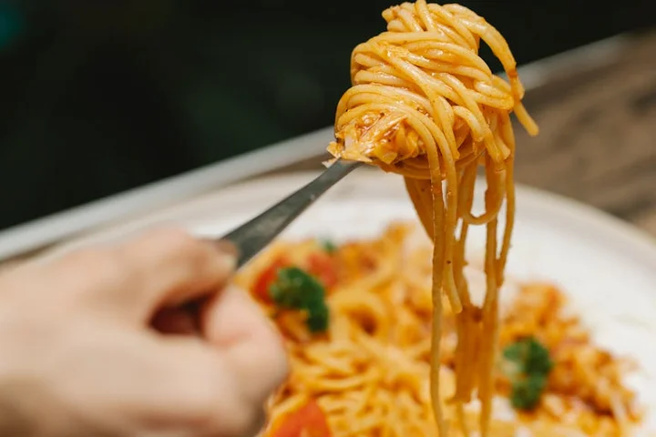 Fork twirling tomato-sauce spaghetti over a plate.