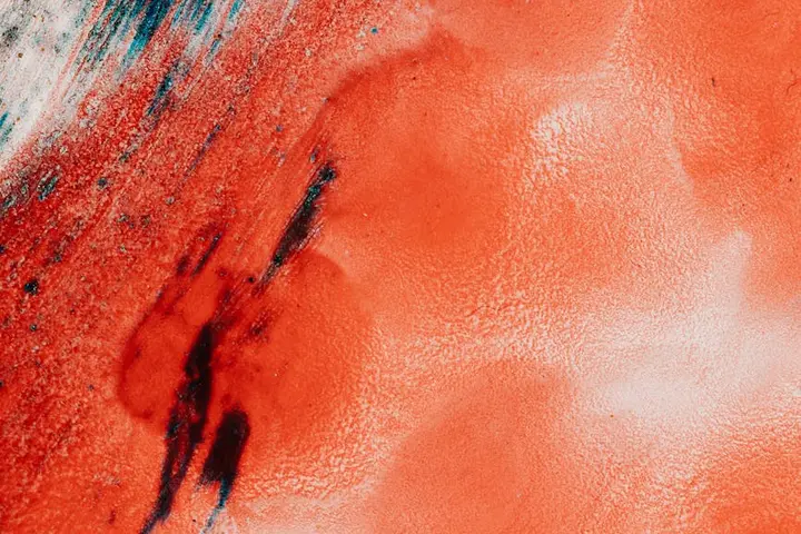 Close-up of a red-orange stained surface with dark streaks, suggesting household stains and cleaning attempts.
