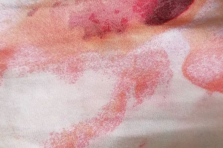 Close-up of fabric with red and pink biological stains
