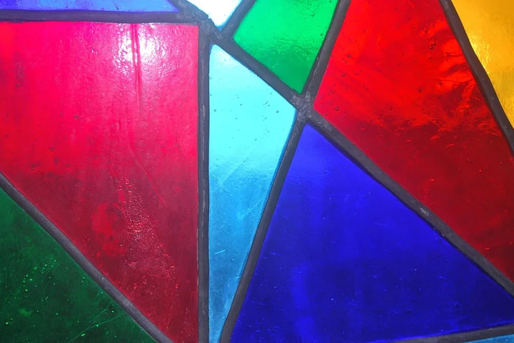 Close-up of colorful stained glass with red, blue, green, and yellow panes