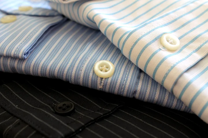 Stack of blue and white striped shirts with button details