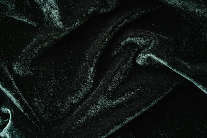 Close-up of dark green velvet fabric with soft folds