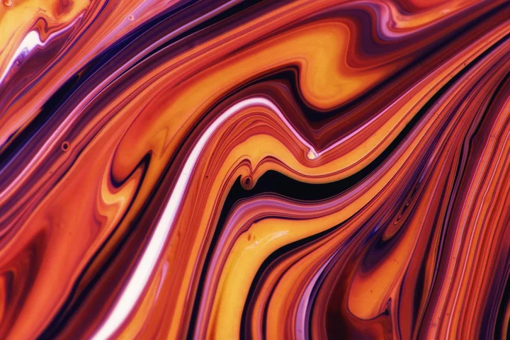 Abstract swirl of orange, purple, and yellow resembling spilled water-based stain to illustrate a tacky, slow-drying mess.