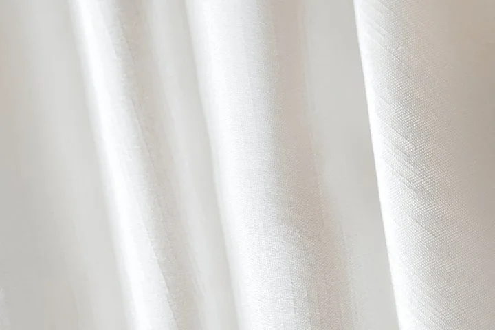 Close-up of white fabric curtains with soft folds