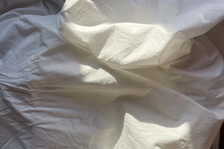 Close-up of wrinkled white fabric, illustrating delicate textiles that require careful handling