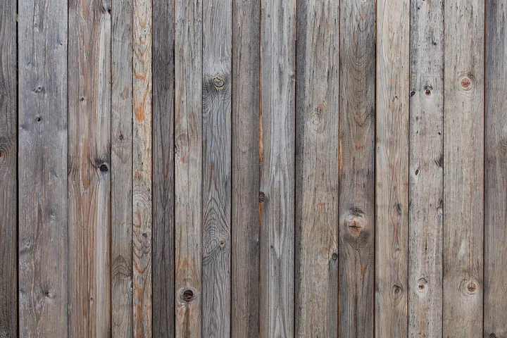 Close-up of weathered vertical wooden floorboards with natural grain and knots.