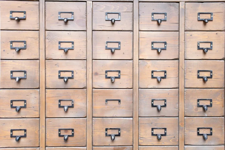 Rows of wooden drawers with metal handles.